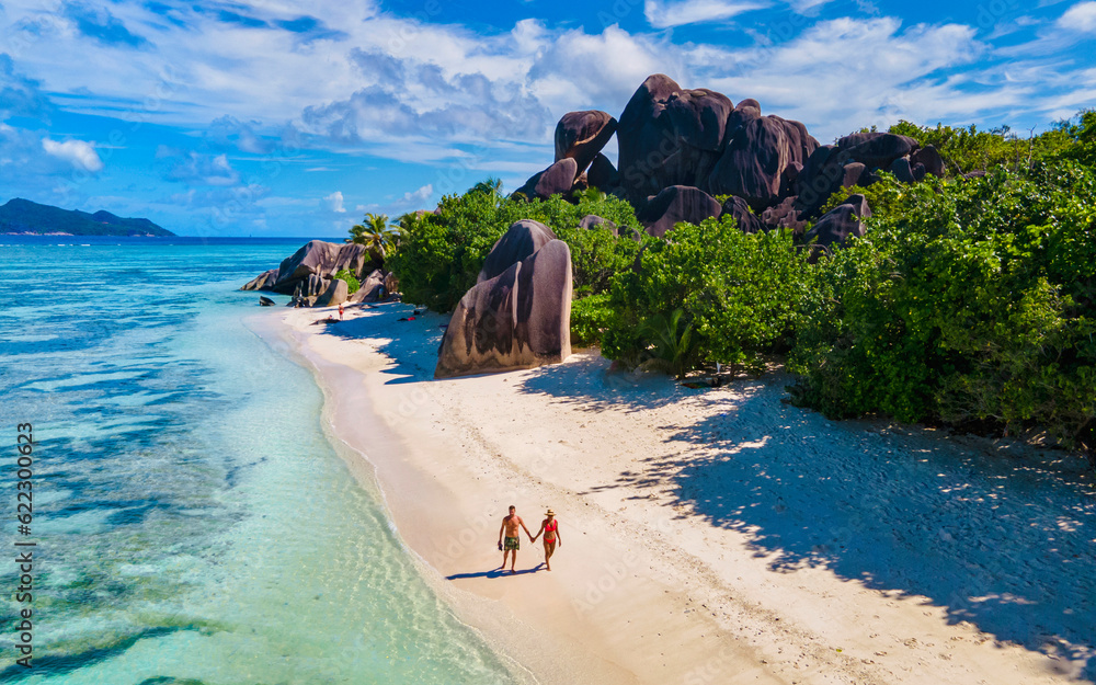 Φωτογραφία Anse Source d'Argent, La Digue Seychelles, a young couple of men and women on a tropical beach during a luxury vacation in Seychelles