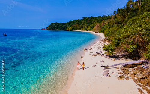 drone view at the beach of Koh Kradan island in Thailand, aerial view over Koh Kradan Island Trang, couple of men and women on the beach during vacation in Thailand © Fokke Baarssen