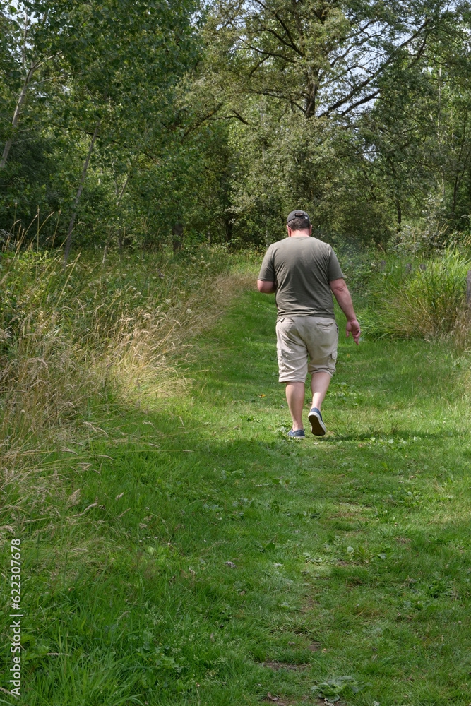 A walk in the park for overweight people while continuing to use a smartphone. Bodypositive. Lifestyle A walk in the park for overweight people while continuing to use a smartphone. Bodypositive. Lifestyle