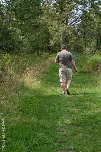 A walk in the park for overweight people while continuing to use a smartphone. Bodypositive. Lifestyle