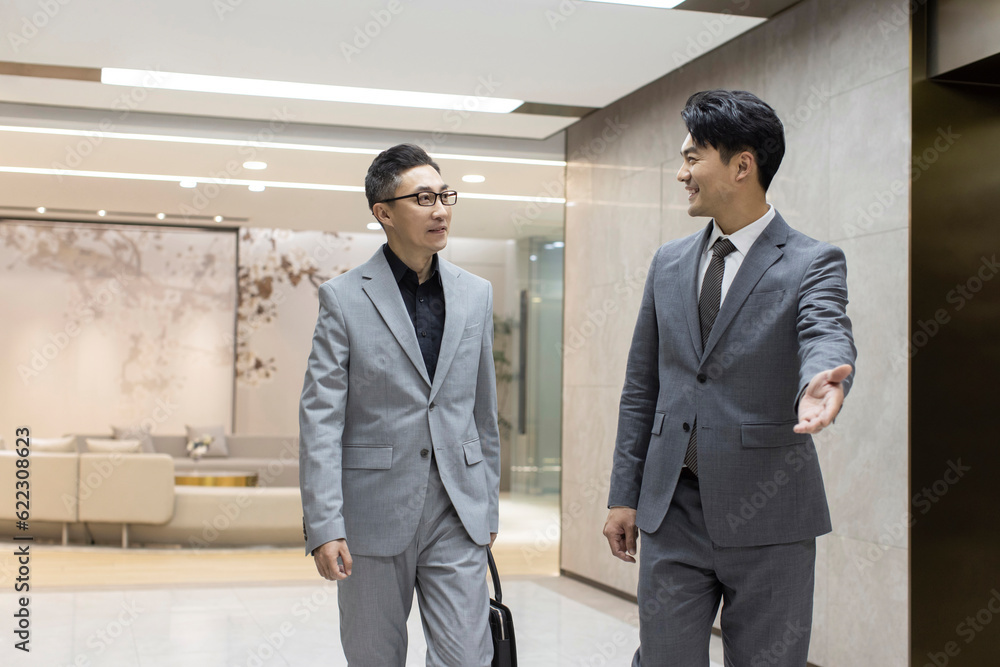 Confident Chinese business people talking in office Confident Chinese business people talking in office