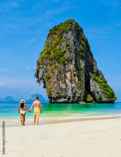 a couple of men and women relaxing on the beach during a vacation in Thailand Railay Beach Krabi. © Fokke Baarssen