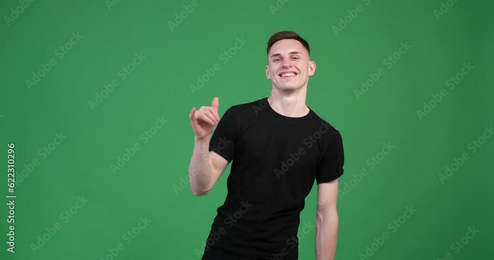 Against a vibrant green backdrop, a content Caucasian man, forming the iconic shaka sign. With a relaxed smile on face, he extends his thumb and pinky finger while keeping the other fingers folded. Against a vibrant green backdrop, a content Caucasian man, forming the iconic shaka sign. With a relaxed smile on face, he extends his thumb and pinky finger while keeping the other fingers folded.