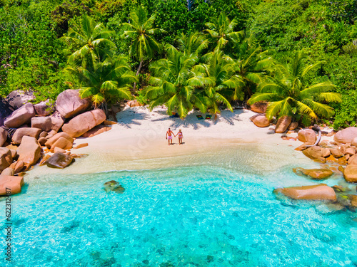 Obraz na płótnie Anse Lazio Praslin Seychelles, a young couple of men and women on a tropical beach during a luxury vacation in Seychelles