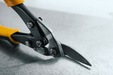 closeup of metal scissors cutting a tin sheet