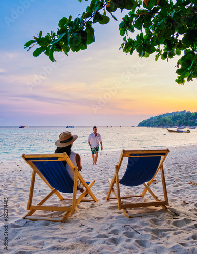 couple relaxing at a beach chair on the beach of Koh Lipe Thailand during sunset  men and women on vacation in Thailand