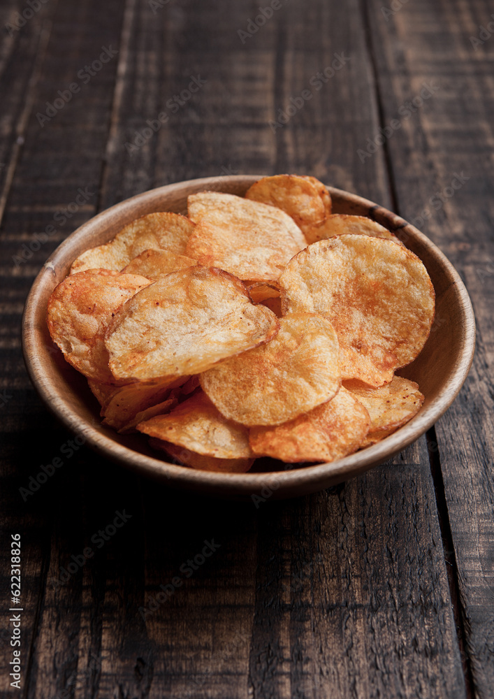 Bowl with potato crisps chips on wooden board. Junk food Bowl with potato crisps chips on wooden board. Junk food