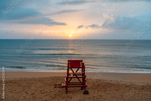 Empty lifeguard chairs at Ormond beach during sunrise