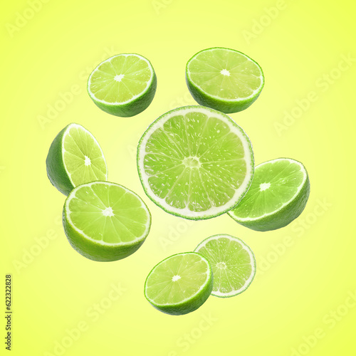 Fresh lime fruits falling on green yellow background