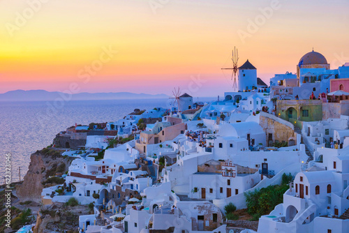 sunset with white churches an blue domes by the ocean of Oia Santorini Greece, a traditional Greek village in Santorini.
