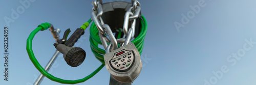 Fotografija Hosepipe locked up with a chain and padlock in a summer heatwave ban concept 3d