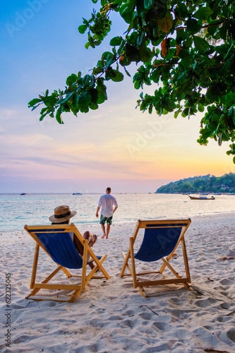 couple relaxing at a beach chair on the beach of Koh Lipe Thailand during sunset