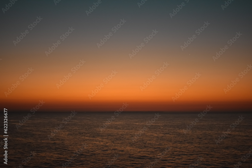 Sunrise sunset orange purple blue pink skies over ocean sea