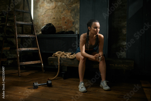 Pensive woman boxer on break from exercise and training