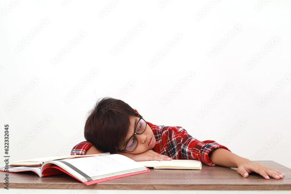 Tired asian student lying down on the desk while studying. Isolated on white Tired asian student lying down on the desk while studying. Isolated on white