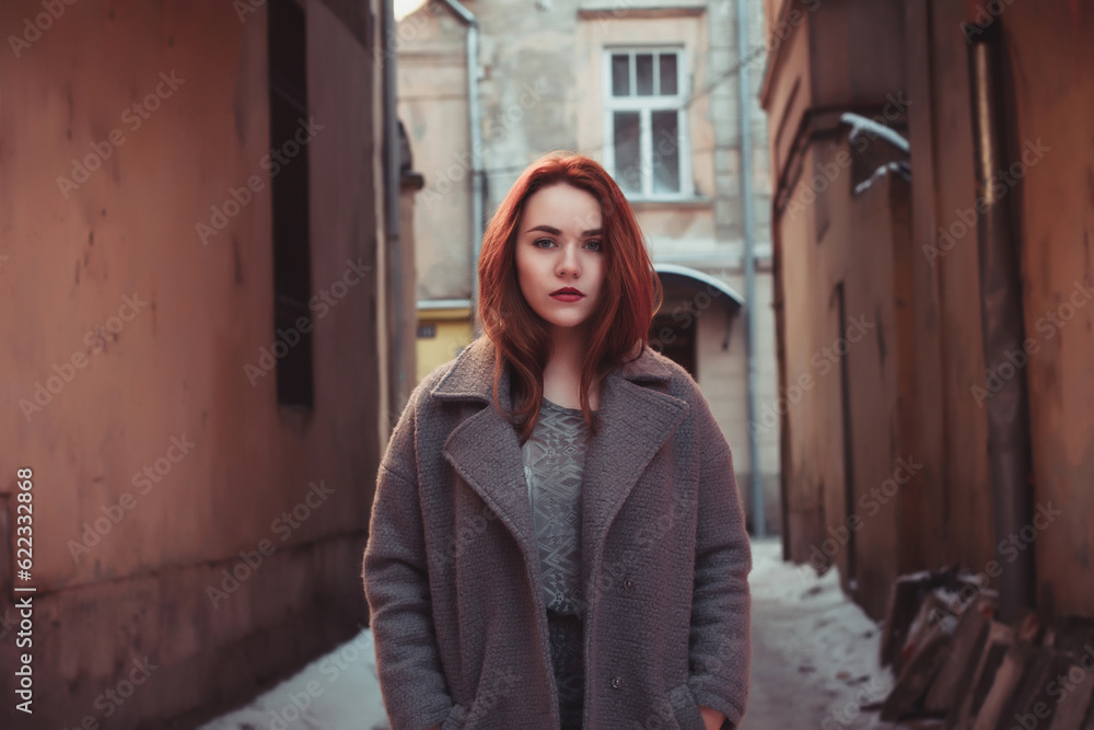 Pretty young redhead woman in a coat