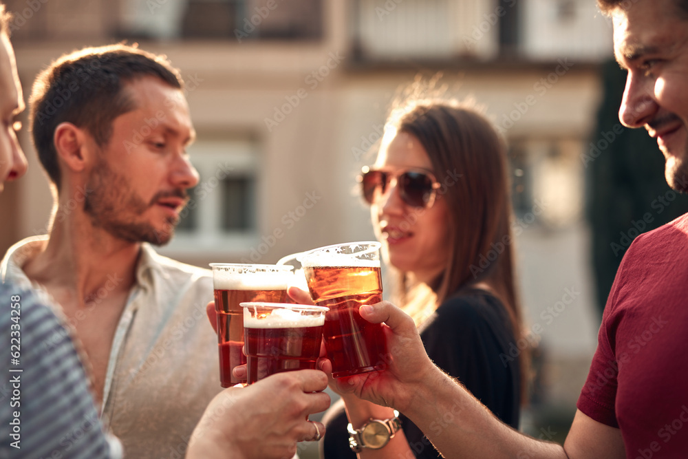 Group of friends enjoying cold beer at a backyard party. Group of friends enjoying cold beer at a backyard party.