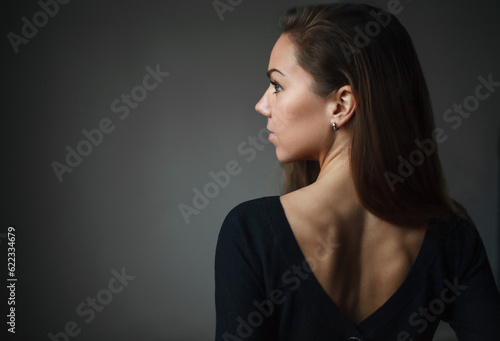 Portrait of beautiful girl turning back in the empty room