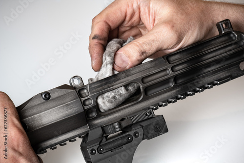 Man`s hands holding rifle parts details and cleaning the gun photo