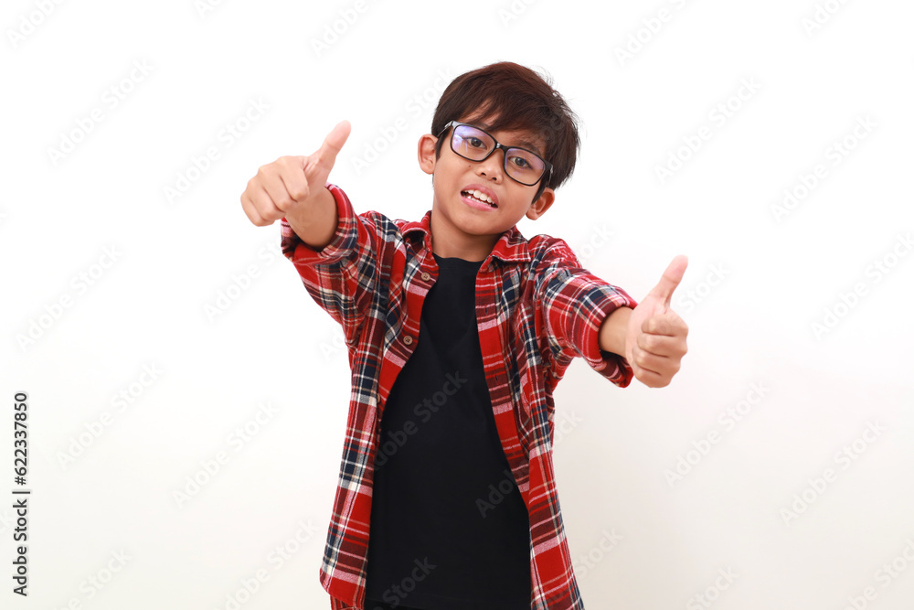 Satisfied Asian boy standing while showing thumbs up. Isolated on white Satisfied Asian boy standing while showing thumbs up. Isolated on white