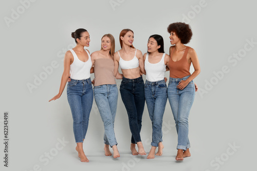 Group of beautiful young women on light grey background