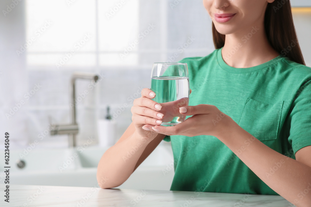 Healthy habit. Woman holding glass with fresh water in kitchen, closeup. Space for text Healthy habit. Woman holding glass with fresh water in kitchen, closeup. Space for text
