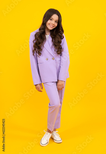 Elegant fashion teenager child girl posing in studio. Trends kids clothes. Happy teenager, positive and smiling emotions of teen girl.