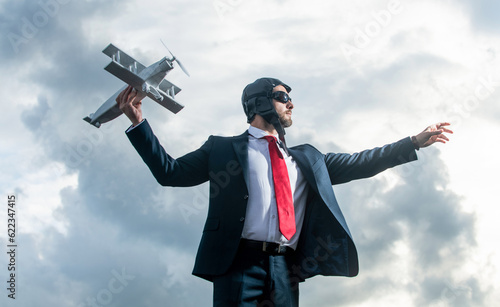 businessman in suit and pilot hat launch plane toy. start business