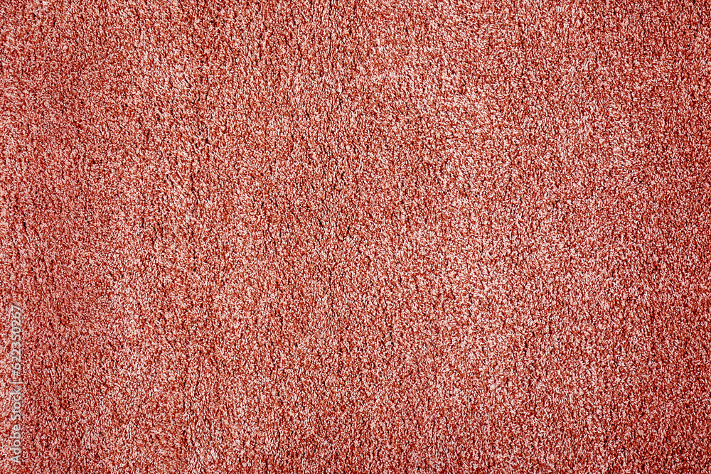 Fototapeta premium Soft coral color carpet as background, top view
