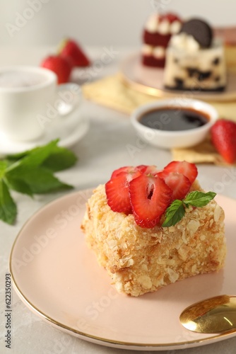 Piece of delicious Napoleon cake with fresh strawberries on light table  closeup. Space for text