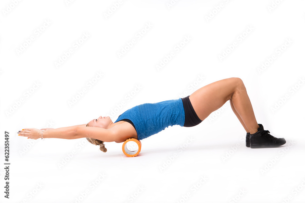 Fitness woman stretching in studio. Young athletic woman training with massage device isolated on white background in studio. Push ups concept.