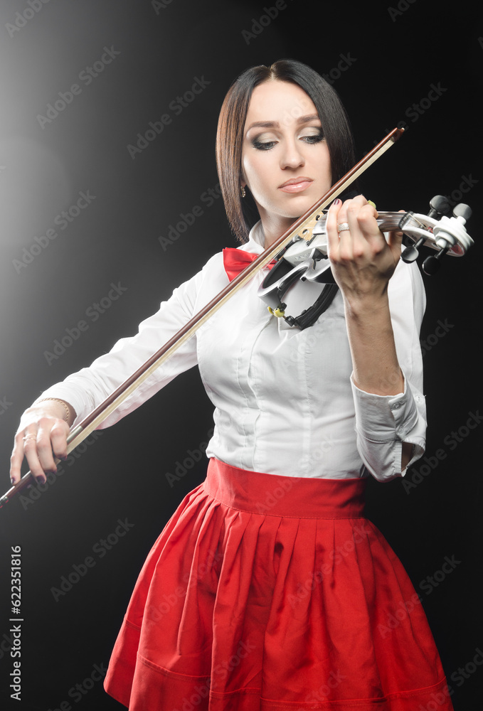 Beautiful woman playing the violin on a black background closing her eyes Beautiful woman playing the violin on a black background closing her eyes