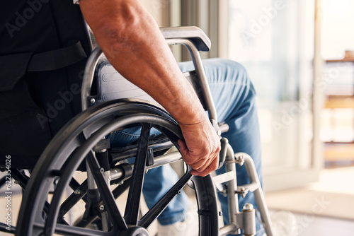 Man, hands and wheelchair for support, hope or travel in healthcare or medicare at home. Closeup of male or person with a disability moving on chair for mobility, surgery or wellness in the house photo