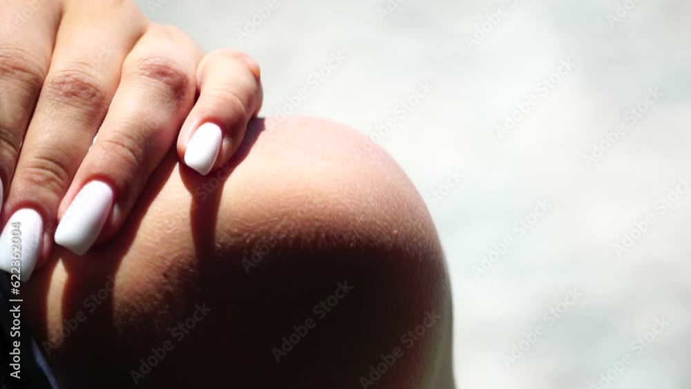 Woman sunblock shoulder. Close up on hand of happy smiling young woman is applying sunscreen or sun tanning lotion on a shoulder. Take care of skin on a seaside beach during holidays vacation. Woman sunblock shoulder. Close up on hand of happy smiling young woman is applying sunscreen or sun tanning lotion on a shoulder. Take care of skin on a seaside beach during holidays vacation.