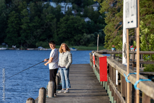 Photography Stockholm, Sweden  A woman and a teenage nephew fishing on a dock on Lake Malaren