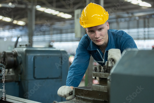 Caucasian man engineering workers wear yellow hard hat working machine lathe metal in factory industrial. mechanical operator male worker. Heavy industry concept.