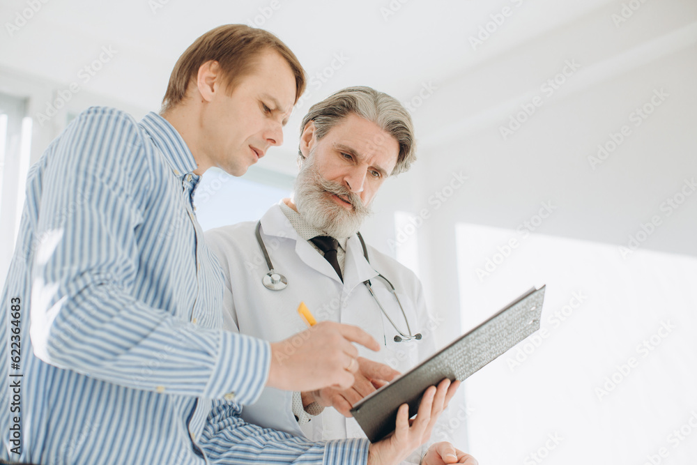 Fototapeta premium Senior doctor giving prescriptions to his patient