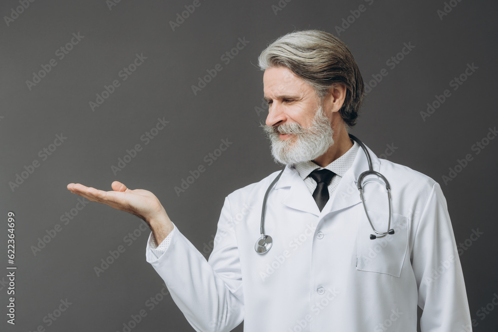 Portait of mature doctor looking at his hand