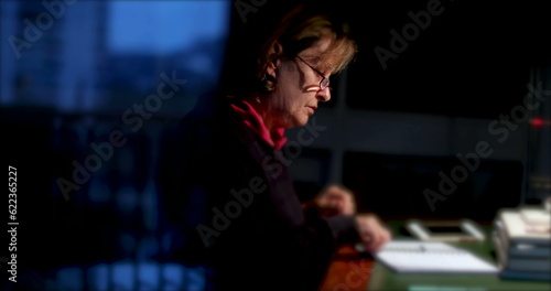 Senior woman writing WILL on paper candid older person writes with pen and paper