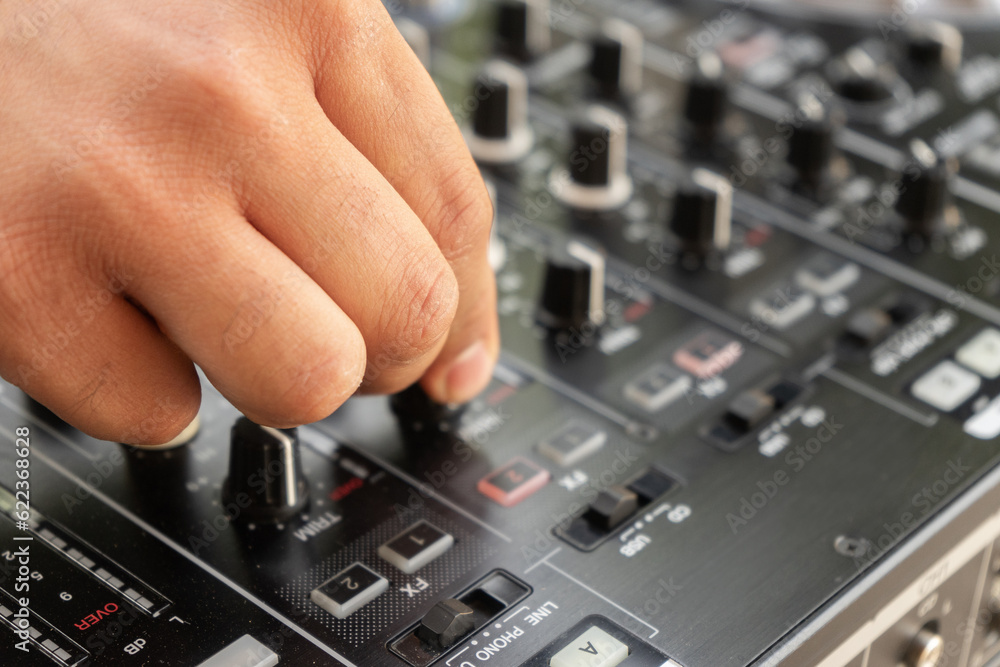 DJ Hands creating and regulating music on dj console mixer in concert party outdoor openair