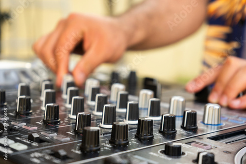 DJ Hands creating and regulating music on dj console mixer in concert party outdoor openair