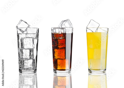 Glasses of cola orange soda lemonade with ice on white background with reflection