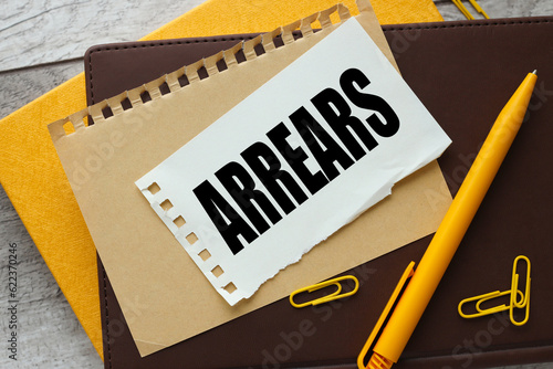 torn paper on torn paper with words Arrears .