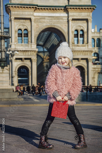 Rediscovering things everybody love in Milan. Full length portrait of elegant girl with red shopping bag at Piazza del Duomo in Milan, Italy standing