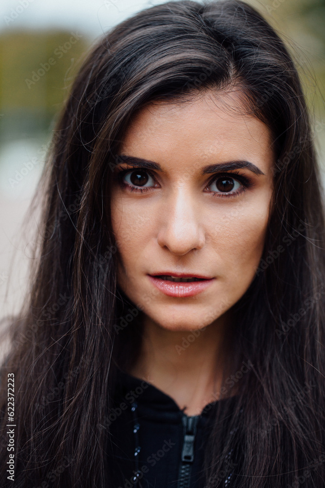 Obraz premium Young beautiful fitness brunette woman looking at camera. Closeup portrait of attractive fit girl after morning workout, female jogger outdoor portrait, healthy and sportive lifestyle.