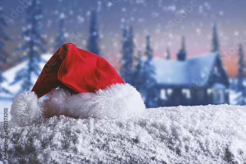 Red velvet Christmas hat of Santa Claus on the snow