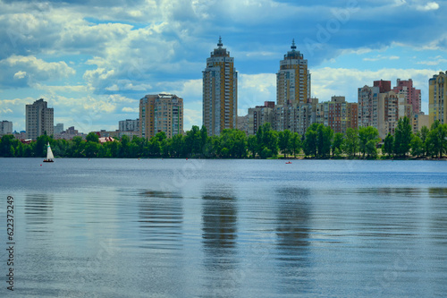 Picturesque panoramic landscape view of Obolon embankment with skyscrapers in the background. Popular place for recreation among locals and tourists.