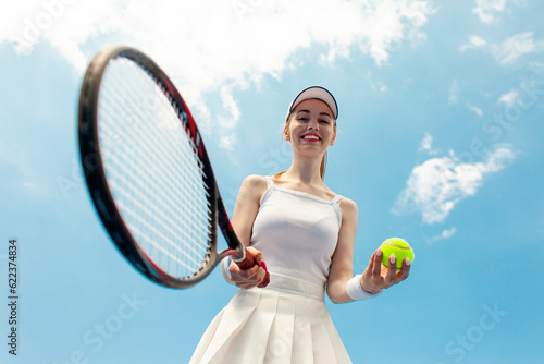 girl tennis player in white uniform holds racket and ball on the tennis court, woman athlete plays tennis © Богдан Маліцький