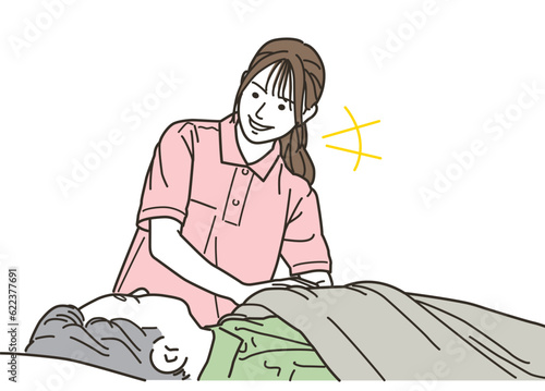 高齢者をベッドで介助する女性介護士
