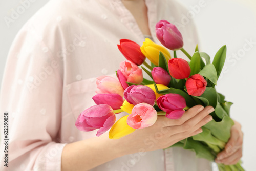 Woman holding beautiful colorful tulip flowers on white background, closeup